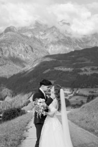 Black-and-white photo of a wedding couple smiling just before a kiss