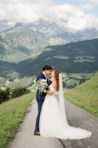 Full-body photo of a wedding couple just before a kiss