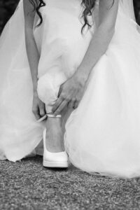 Close-up of the bride’s shoes while she fastens them