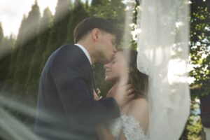 Landscape vintage grainy photo of a groom kissing his bride on the forehead