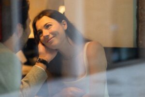 Vintage photo of a woman in a café as her husband holds her cheek and she gazes at him lovingly