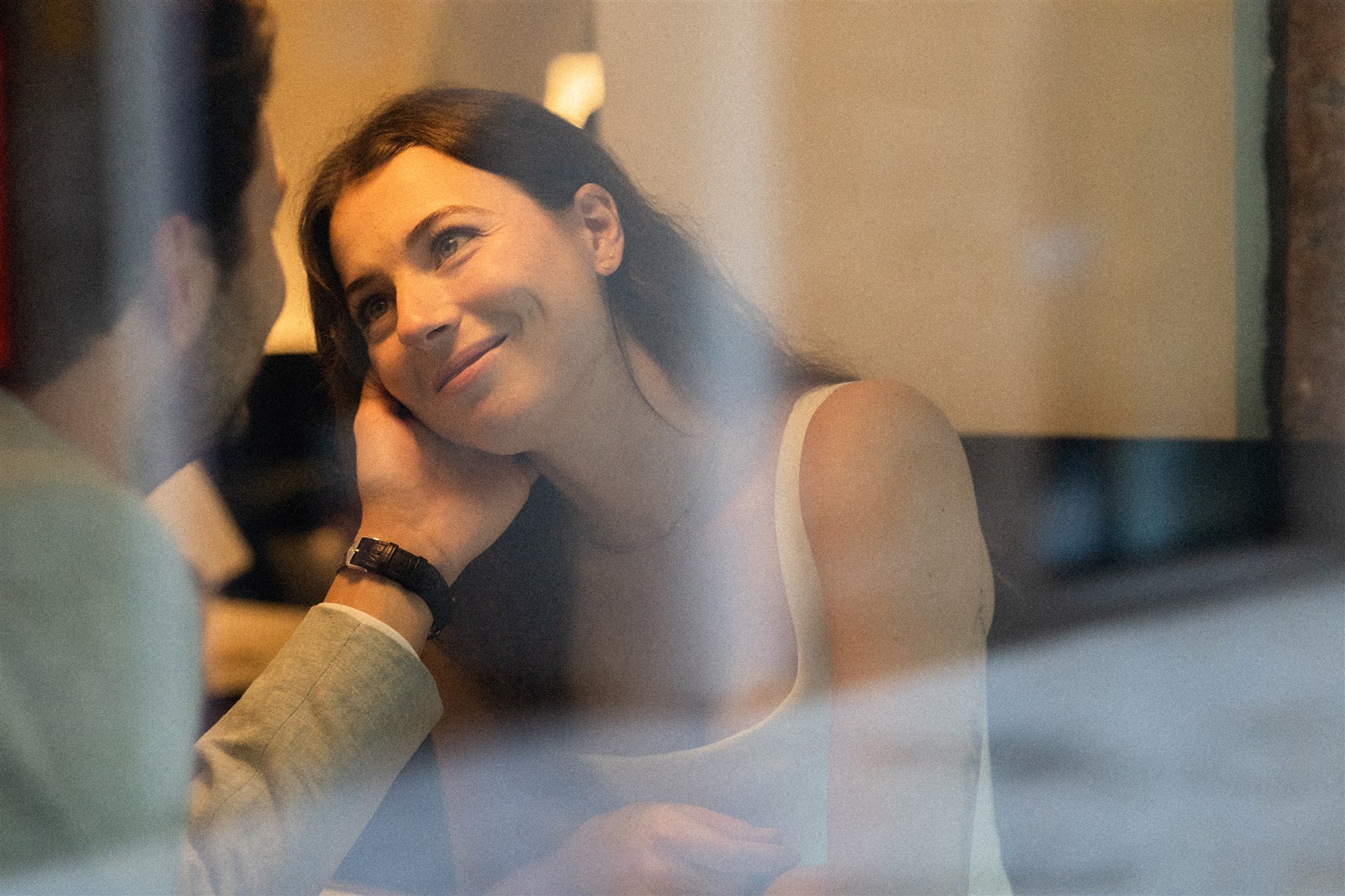 Vintage photo of a woman in a café as her husband holds her cheek and she gazes at him lovingly
