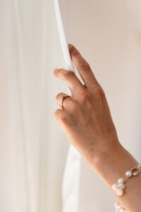 Close-up of the bride's hand gliding along her dress