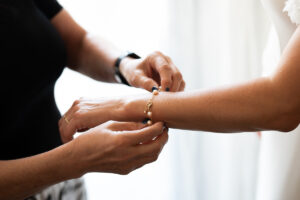 Close-up of the bride's mother fastening her bracelet