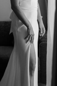 Black and white close-up of the bride's legs with the dress slit visible