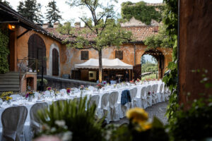 White reception table in the castle courtyard with terracotta walls in the background