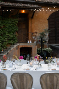 Evening atmosphere at the reception table with string lights and terracotta walls