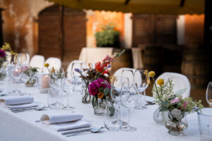 Close-up of table decor with flowers and terracotta walls in the background