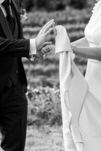 Close-up of a bride and groom's hands while dancing, with the wedding dress flowing in motion