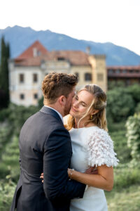 Groom kissing his bride on the cheek while she closes her eyes and smiles