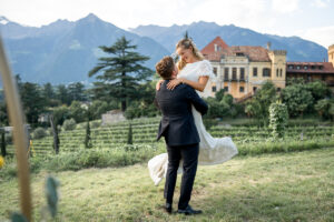 Bride being twirled by her groom as her dress flows through the air