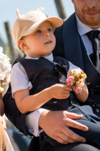 The couple's son sits on the groom's lap looking ahead