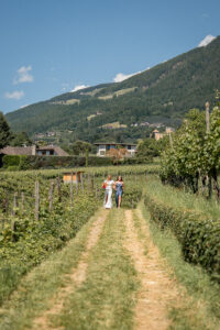 The bride walks with her mother through the vineyards toward the ceremony location