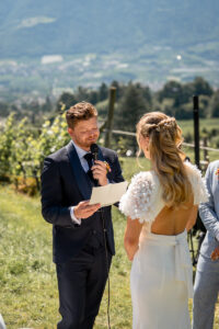 The groom reads his vows to the bride while looking down
