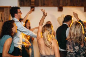 Guests dancing at the wedding reception with their hands raised