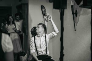Black-and-white photo of the shoe game with the laughing wedding couple