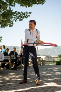 Groom participating in a wedding challenge with a hula hoop