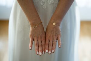 Detail photo of the bride’s hands with jewelry and polished nails