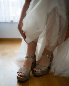 Detail photo of the bride holding up her dress in backlight