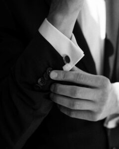 Black-and-white detail photo of a suit sleeve with cufflink