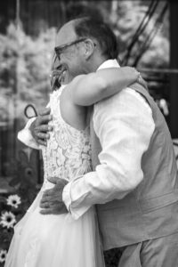 Black-and-white photo of an intimate embrace between the bride and her father