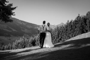 Black-and-white photo of the wedding couple from behind overlooking the mountains