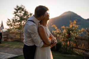 Groom kissing his bride on the cheek at sunset