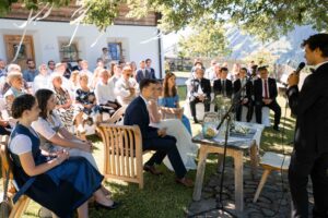 Wide-angle photo of the outdoor ceremony beneath a tree