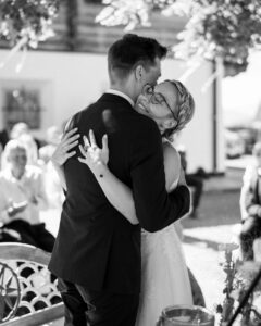 Black-and-white photo of the couple embracing after the ring exchange