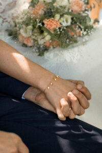 Close-up of the wedding couple’s hands with visible wedding rings