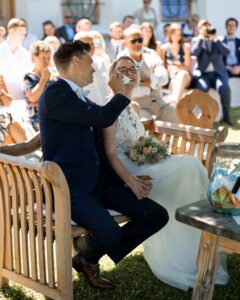 Groom wiping tears from his laughing bride’s face