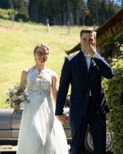 Wedding couple walking hand in hand to their ceremony while the groom looks emotional