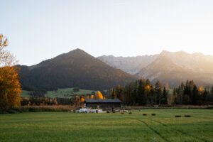 Wedding venue glowing in golden evening light against an autumn mountain backdrop