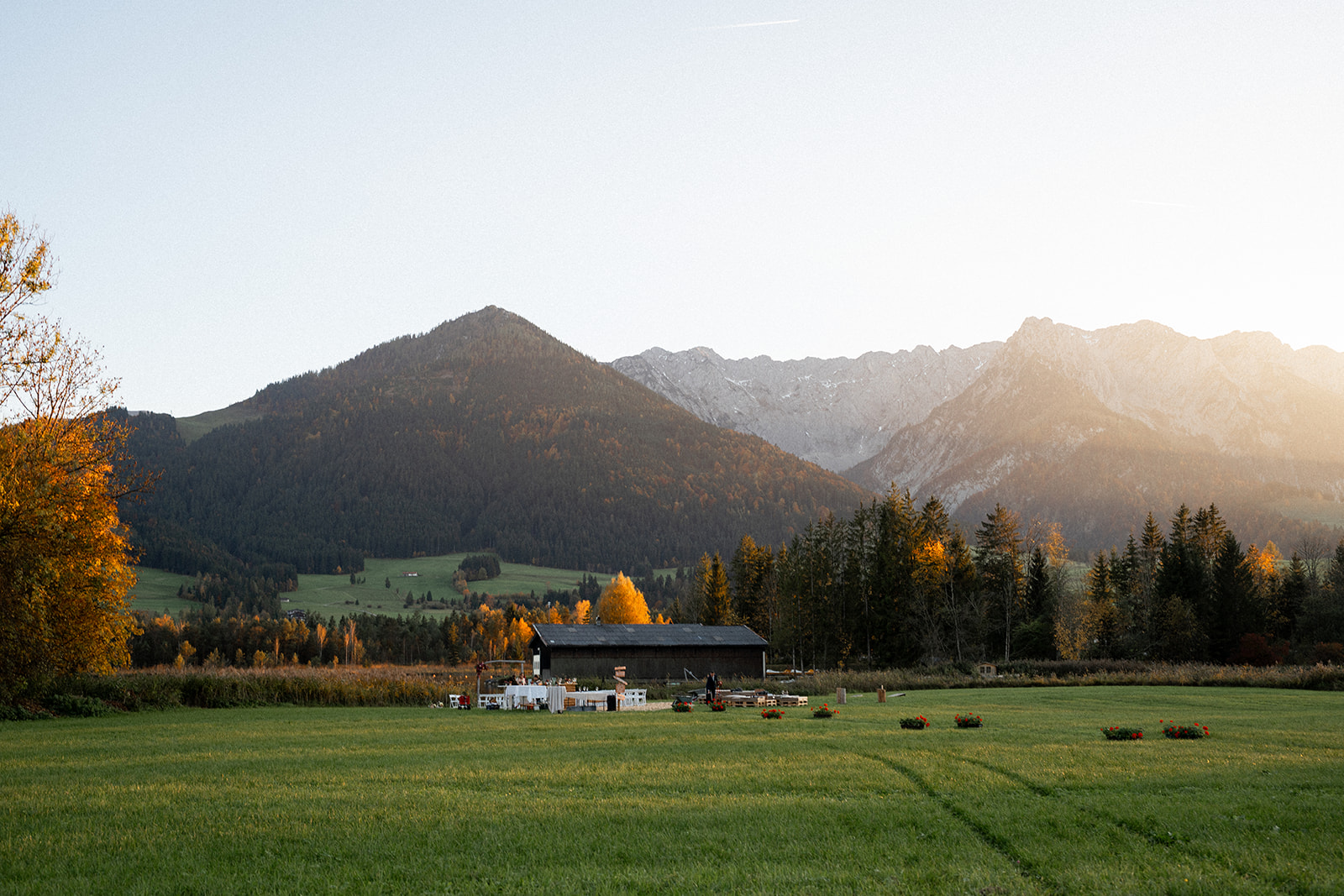 Wedding venue glowing in golden evening light against an autumn mountain backdrop