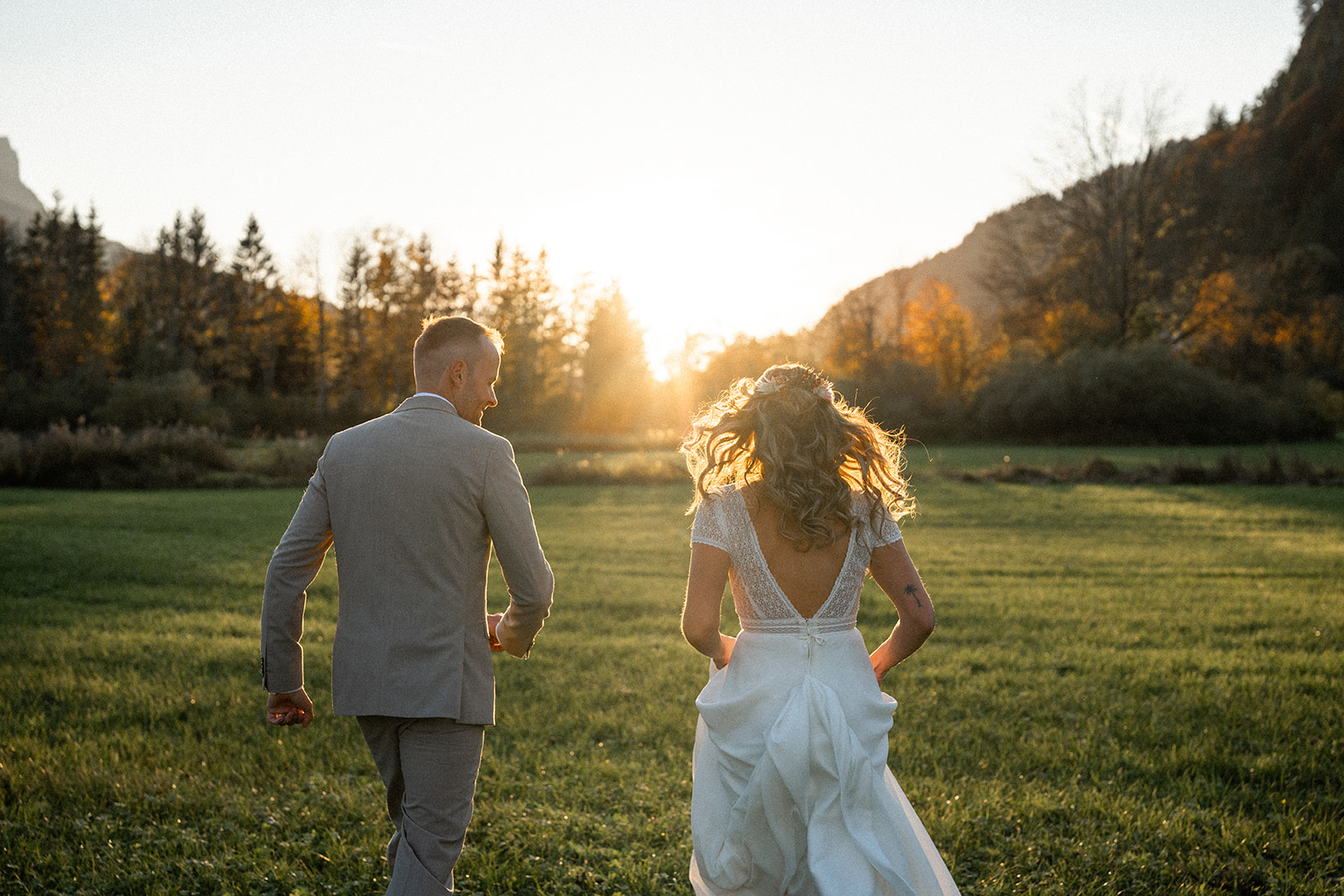 Young wedding couple walking freely and happily towards the autumn sunset