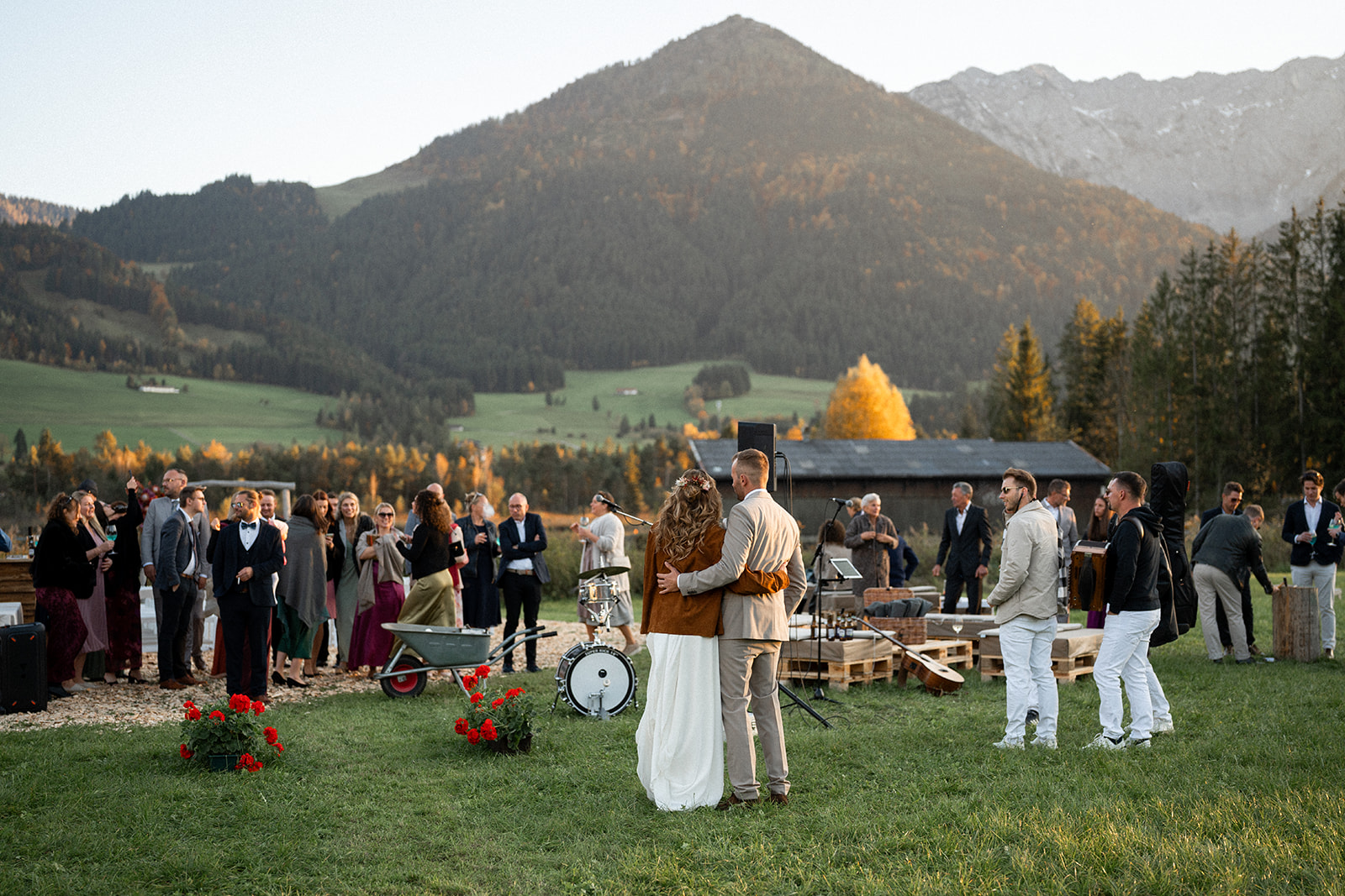 Wedding reception toast with the couple in front of autumn mountains at sunset