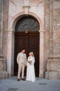 Wedding couple standing in an archway in the old town while looking at each other