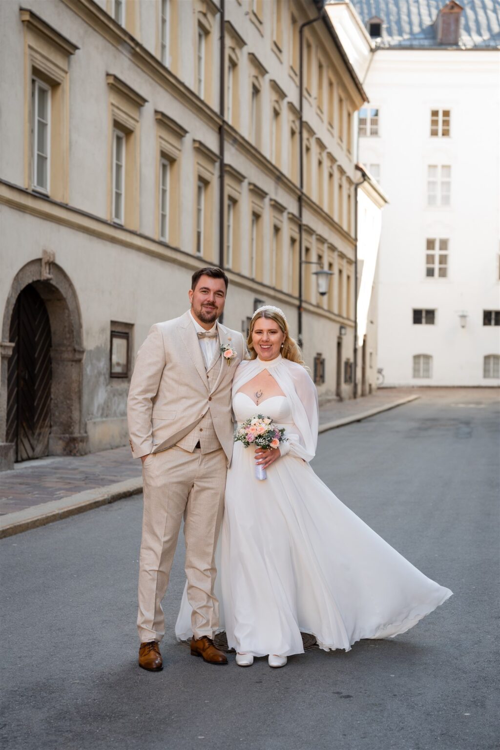 Young wedding couple laughing at the camera in Innsbruck’s old town
