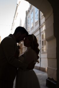 Silhouette of a couple in an archway with Innsbruck’s old town in the background