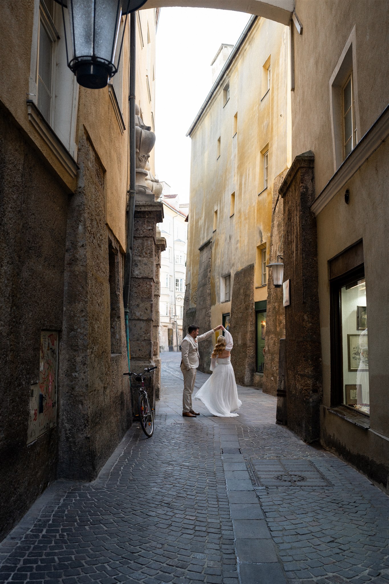 Wedding couple in the old town while the groom twirls the bride