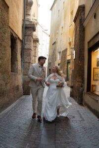 Wedding couple walking toward the camera laughing while the dress flows through the air