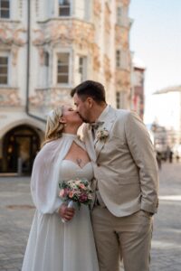 Slightly blurred vintage photo of a wedding couple kissing in the old town