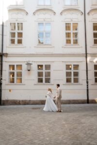 Vintage side-view black-and-white photo of a wedding couple walking through the old town