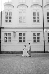 Vintage slightly blurry black-and-white photo of a wedding couple from behind walking through the old town