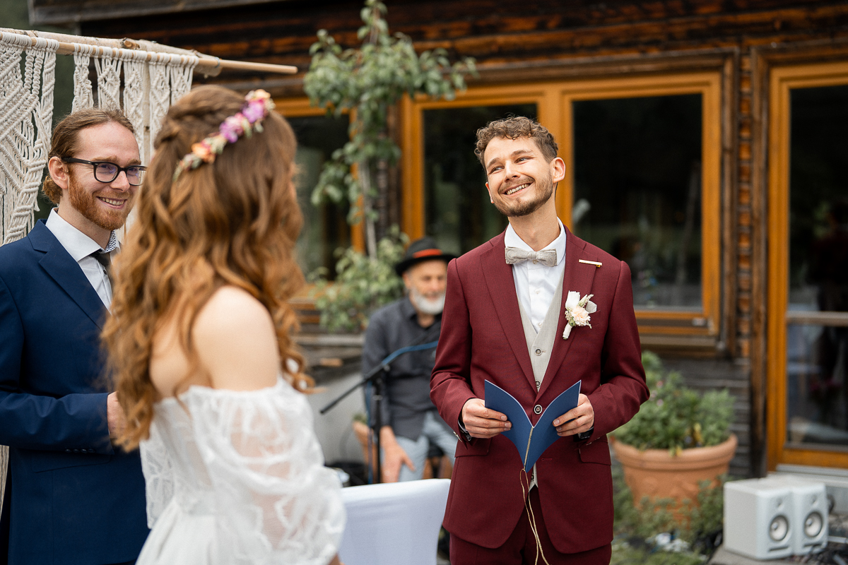 Over-the-shoulder photo of the groom reading his vows to his bride