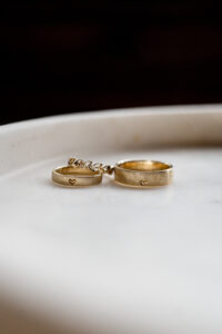 Close-up of the two wedding bands and the engagement ring positioned above the bride's wedding ring