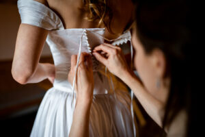Close-up of hands threading the corset laces
