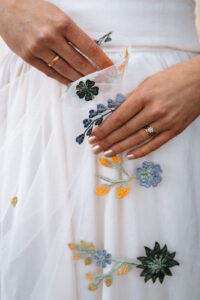Close-up of hands holding a floral embroidered veil