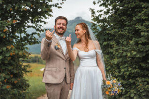 The newlyweds show their ring fingers and laugh together.