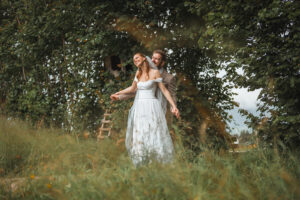 The groom whispers into his bride's ear while they both laugh warmly